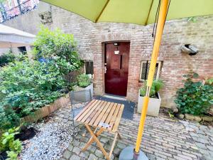 a wooden bench sitting in front of a house with an umbrella at City Nook in Utrecht +3 photos