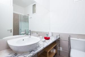 a bathroom with a large white tub and a sink at Designer Flats in Lapa by LovelyStay in Lisbon +135 photos
