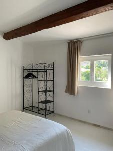 a white bedroom with a bed and two windows at Villa charmante à Villecroze avec piscine privée in Villecroze
