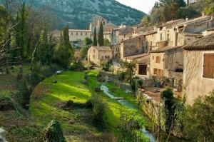 an image of a village with a river and buildings at La Maison de Faustin in Saint-Guilhem-le-Désert