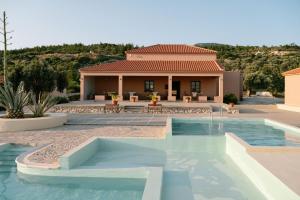 a villa with a swimming pool and a house at Mandilada Family Village - Seaview Villas in Marathokampos