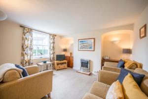 a living room with two couches and a tv at Bovis Cottage, Southwold in Southwold