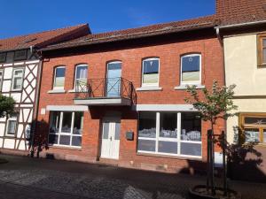un bâtiment en briques rouges avec des fenêtres et un balcon dans l'établissement Ferienwohnungen Garzke, à Neustadt