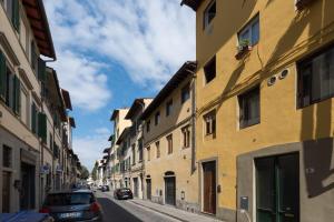 un callejón con edificios y un coche aparcado en una calle en Roommo Carmine, en Florencia