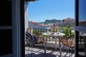 a balcony with a table and chairs and a view at Elysee Seaview Apartments in Sidari