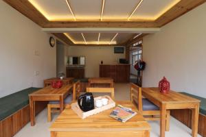 a dining room with wooden tables and chairs at Hotel Green Oak in Nainital