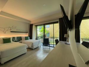 a hotel room with two beds and a balcony at TREX Buriram Boutique Hotel in Buriram +45 photos