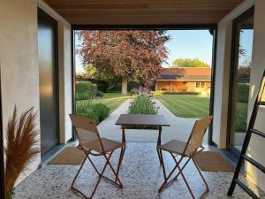 a patio with a table and two chairs and a yard at Villa Couleur - Holiday Home in Diksmuide