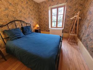 a bedroom with a bed with blue sheets and a ladder at Maison Coeurdacier 15 personnes 6 chambres in Monthureux-sur-Saône