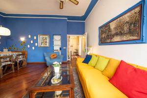 a living room with a yellow couch and a table at Casa nel Borgo Toscano- Casole d'Elsa in Casole dʼElsa