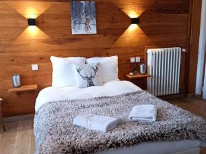 a bedroom with a bed with two towels on it at Hotel Restaurant Le Col de Crous in Péone