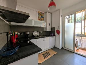 Una cocina con gabinetes blancos y una encimera negra. en Appartement familial - Vue mer, en Bastia 6 fotos más