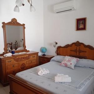 Un dormitorio con una cama con una cómoda y un espejo. en Martino10, en Carloforte
