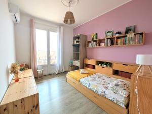 Un dormitorio con una cama y una pared morada. en Appartement familial - Vue mer, en Bastia