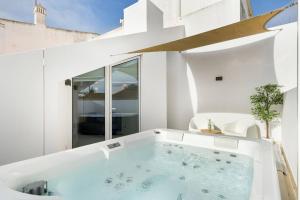 a bath tub in a white room with a window at Luxury Historic House with Private Jacuzzi in Lagos