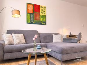 a living room with a couch and a table at Komfort Ferienwohnungen mit Wellness-Garten - Gästehaus am Bachlauf - Losheim am See in Losheim