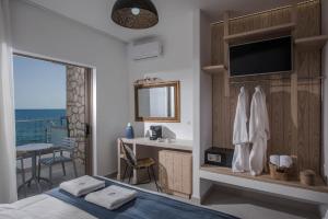 a bedroom with a bed and a desk with a television at Serenity Spritz Boutique Hotel - Adults Only in Hersonissos