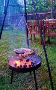 un gril avec de la nourriture dessus dans une cour dans l'établissement Pokoje gościnne u Brody, à Międzybrodzie Żywieckie 3 autres photos