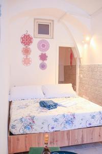 Una cama en una habitación con algunas decoraciones en la pared. en Dimora Cenci - Almalusa Apulian Home by In Puglia service, en Martina Franca