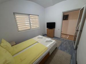 a bedroom with a yellow bed and a television at Apartament central zone in Sibiu
