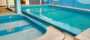 a large swimming pool with blue tiles in a building at Kanaprime Hotels & Safaris Shanzu pride in Mombasa