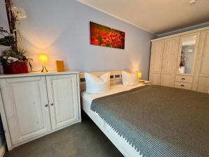 a bedroom with a bed and a painting on the wall at Aquamarin Ostseetraumsuite 01 in Neuhaus