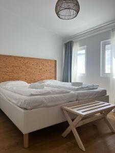 a bedroom with a large white bed and a bench at Beachfront Caparica in Costa da Caparica