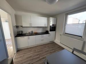 an empty kitchen with white cabinets and a window at Monteurwohnung Gieboldehausen in Gieboldehausen