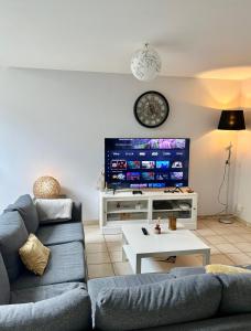 un salon avec un canapé et une télévision à écran plat dans l'établissement Maison calmer & confort, au Mans