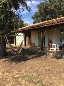 a hammock hanging from a porch of a house at maison residence les arros in Soulac-sur-Mer