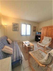 a living room with a bed and a table at maison residence les arros in Soulac-sur-Mer