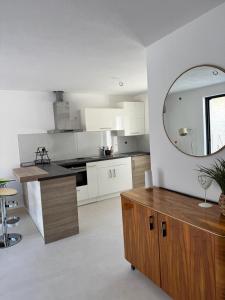 cocina blanca con espejo y mesa en Smokvica, en Senj