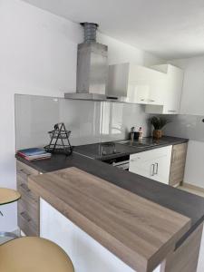 cocina con armarios blancos y encimera gris en Smokvica, en Senj