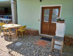 a patio with a table and chairs and a wooden door at B&B La Taerra in Porto San Paolo