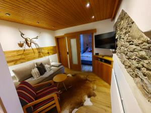 un soggiorno con un divano e una TV di Haus Groder a Rauris