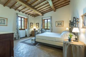 a bedroom with a bed and a table and two windows at IL POGGIO ALLE TRESE 14, Emma Villas in Città della Pieve