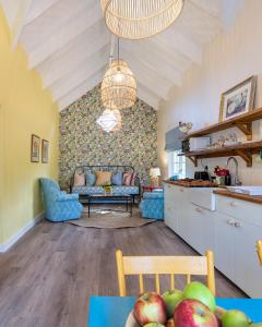 une cuisine et un salon avec un canapé et une table dans l'établissement Bramley Cottage, Cheverells Farm, à Grabouw