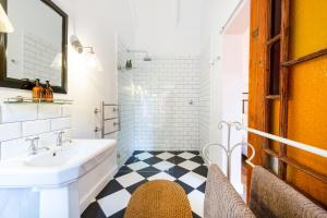 La salle de bains est pourvue d'un lavabo blanc et d'un sol noir et blanc. dans l'établissement Bramley Cottage, Cheverells Farm, à Grabouw