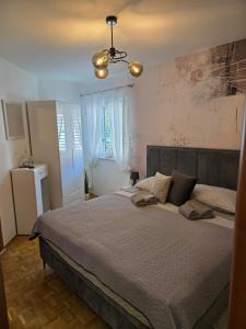 a bedroom with a large bed and a window at Apartmani Andiks Dramalj in Dramalj