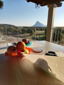 a table with some fruit on a table with a view at B&B La Taerra in Porto San Paolo