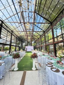 a room with white tables and chairs in a greenhouse at Altamers Mountain Resort 