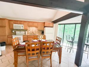 a kitchen with a dining room table and chairs at Treehouse Treetop Village58-3bed3bapools-8pp in Four Seasons