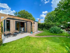 PeizeTiny House The Cabin的带木质甲板和草坪的花园房