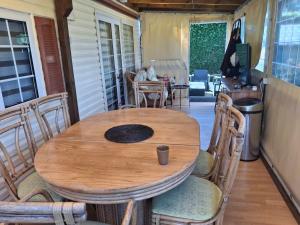 a wooden table and chairs on a porch at Camping bois dormant in Quend-Plage
