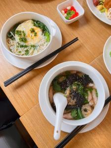 a table with a bowl of soup and a bowl of noodles at Atour X Hotel - Taikoo Li Chengdu in Chengdu