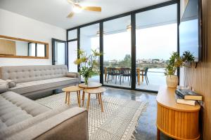 a living room with a couch and tables and windows at Villa Guadiana Golf 2 in Ayamonte