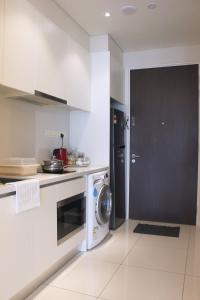 a kitchen with a washing machine and a black door at The Amber Residence Putra Height by Sleepy Bear in Teluk Panglima Garang