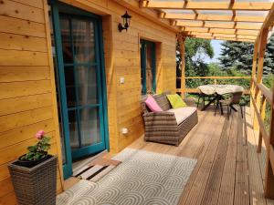 a wooden deck with a couch and a table on it at Healing Garden Leányfalu in Leányfalu +7 photos