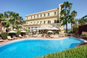 a pool in front of a hotel with chairs and umbrellas at Imperial Hotel Tramontano in Sorrento