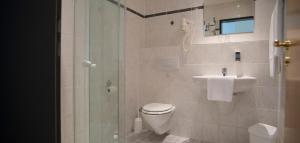 a bathroom with a toilet and a sink and a shower at Hotel-Restaurant Öhlers in Hannover +12 photos
